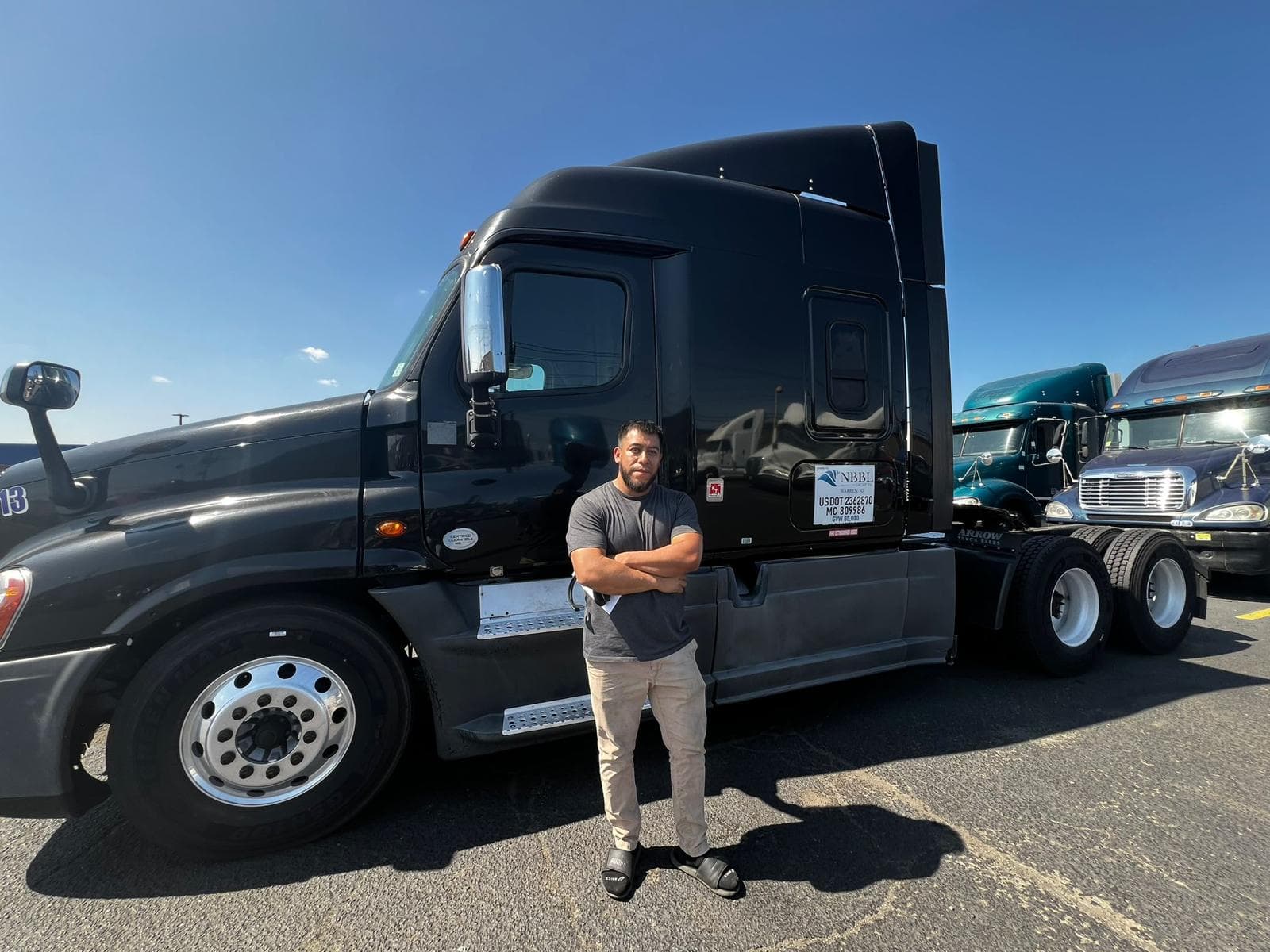 NBBL Group driver with black Freightliner Cascadia at port terminal